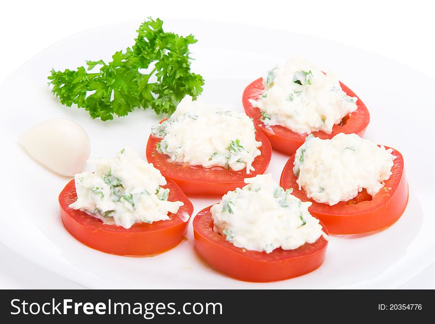 Sliced tomato with cheese and garlic sauce on a plate. Sliced tomato with cheese and garlic sauce on a plate