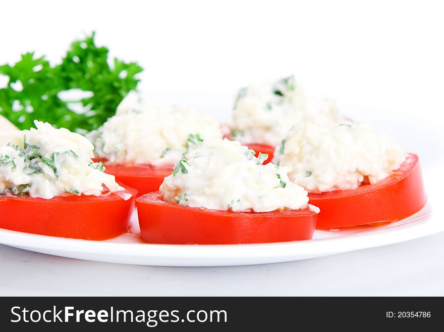 Sliced tomato with cheese and garlic sauce on a plate. Sliced tomato with cheese and garlic sauce on a plate