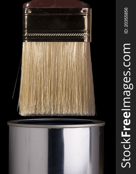 Clean paintbrush dipping into a silver can. Clean paintbrush dipping into a silver can.