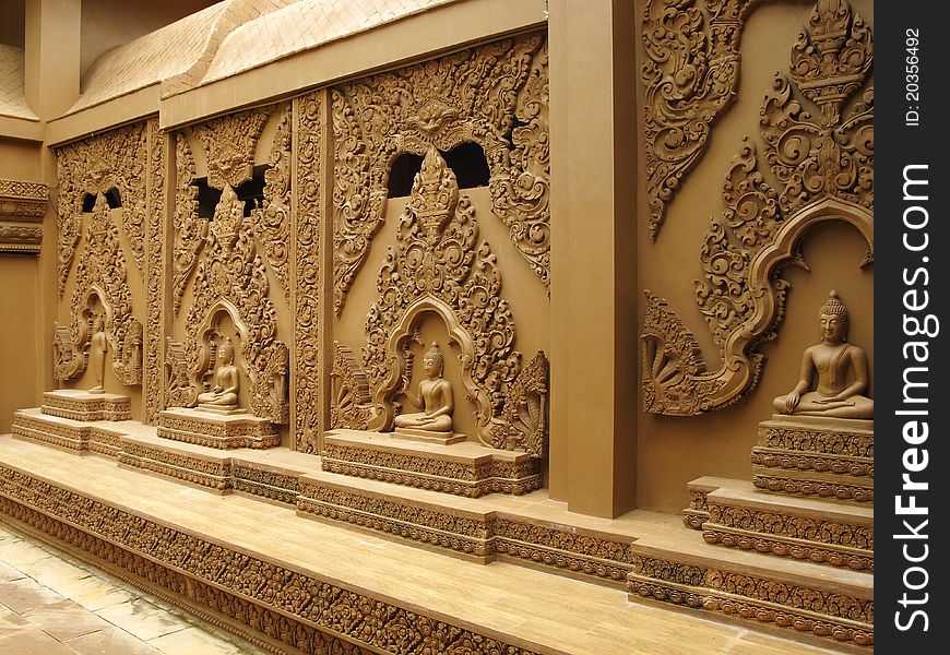 Row of sitting Budhha statues along the wall of a temple in Kanchanaburi, Thailand. Row of sitting Budhha statues along the wall of a temple in Kanchanaburi, Thailand