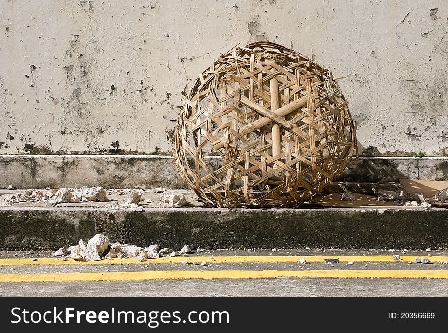 A Basket at the side of a road littered with stone debris. A Basket at the side of a road littered with stone debris