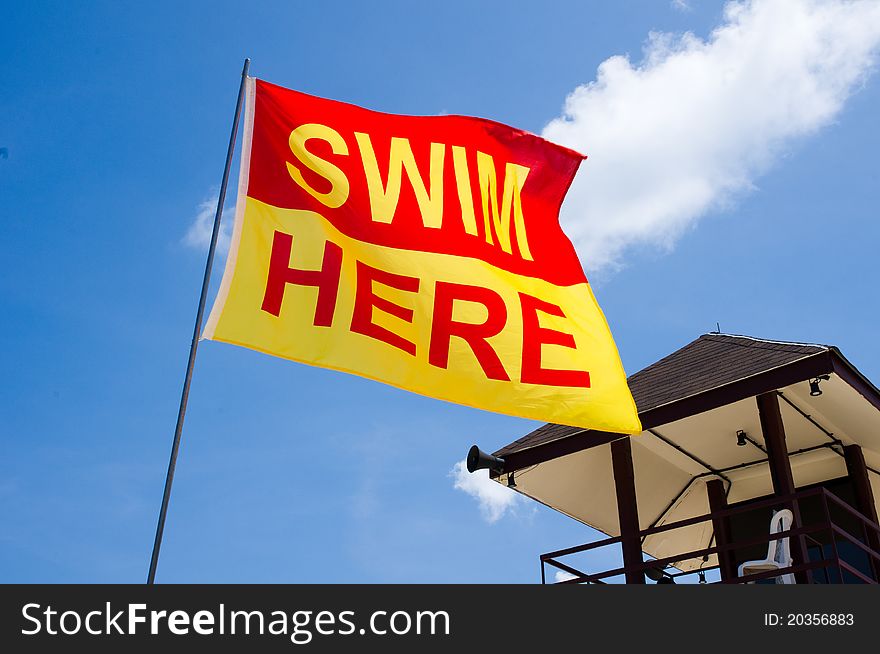 A Swim Here Flag along a beach to signal that it is a safe swim zone. A Swim Here Flag along a beach to signal that it is a safe swim zone