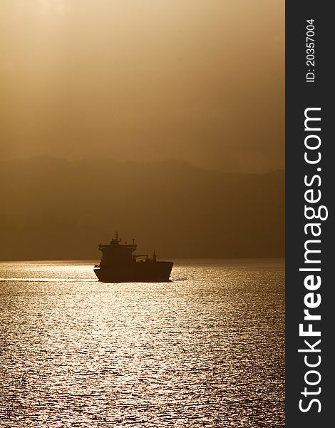 A ship carrying cargo freight or fuel leaving the island of St. Lucia as a golden dawn light breaks over the island, the primary economic life line for the small Caribbean island nation. A ship carrying cargo freight or fuel leaving the island of St. Lucia as a golden dawn light breaks over the island, the primary economic life line for the small Caribbean island nation.