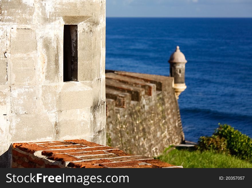 A beautiful close up view of an observation window in a guerite, or sentry box, with another guerite and the Caribbean Sea in the distance along the coastal side of Fort San Cristobal in Old San Juan, Puerto Rico. Also known as Castillo de San Cristóbal, it was the largest fort ever built by the Spanish in the New World, designed to help protect San Juan from land based attacks. A beautiful close up view of an observation window in a guerite, or sentry box, with another guerite and the Caribbean Sea in the distance along the coastal side of Fort San Cristobal in Old San Juan, Puerto Rico. Also known as Castillo de San Cristóbal, it was the largest fort ever built by the Spanish in the New World, designed to help protect San Juan from land based attacks.