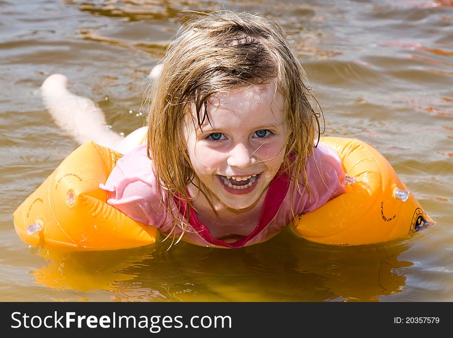 Little happy girl swimming in the sea