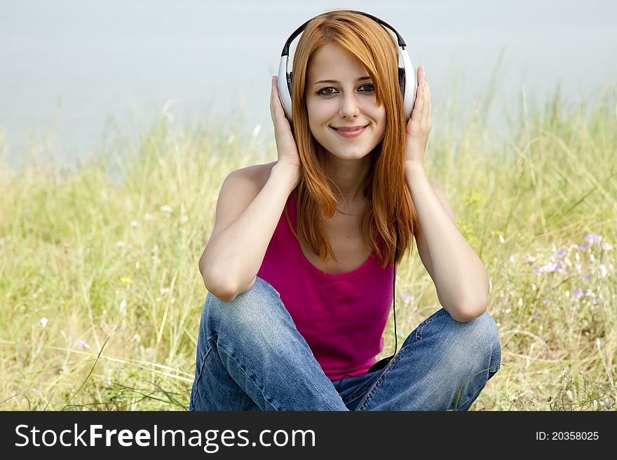 Redhead girl with headphone. Outdoor
