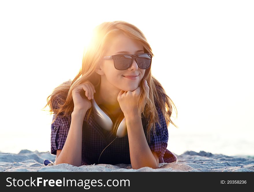 Girl with headphones at beach sand.