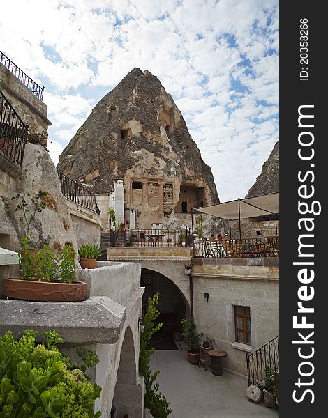 Turkish villa, built into caves, with verandas, canopies, awnings under a cloudy sky. portrait with copy space. Turkish villa, built into caves, with verandas, canopies, awnings under a cloudy sky. portrait with copy space