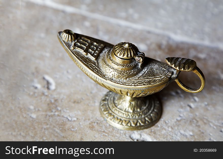 Aladdin style arabian oil lamp with handle and etchings made from brass bronze horizontal copy space. Aladdin style arabian oil lamp with handle and etchings made from brass bronze horizontal copy space