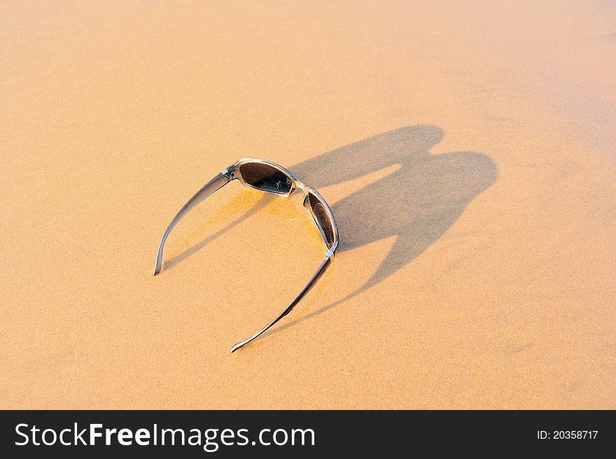 Sun glasses on the sandy sea shore