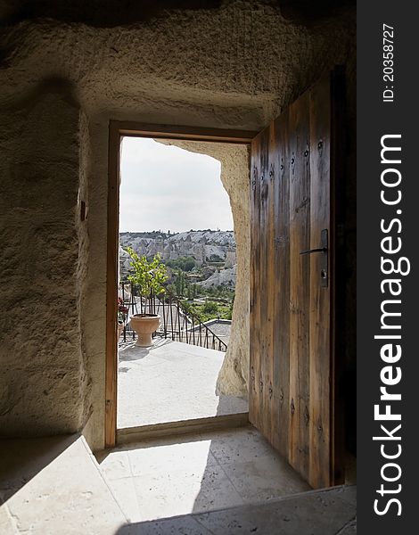 Open doorway of Koza Cave with a view of Goreme hills and natural chimney caves, Cappodocia, Turkey. Portrait copy space. Open doorway of Koza Cave with a view of Goreme hills and natural chimney caves, Cappodocia, Turkey. Portrait copy space