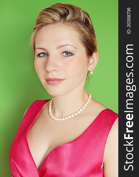 Beautiful woman in the pink dress against the green background. Beautiful woman in the pink dress against the green background