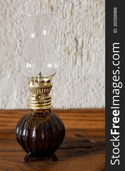 Ornamental oil lantern on a side board with limestone background. Ornamental oil lantern on a side board with limestone background