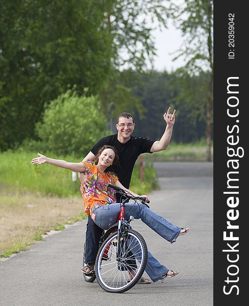 Happy couple sitting together at one bicycle. Happy couple sitting together at one bicycle