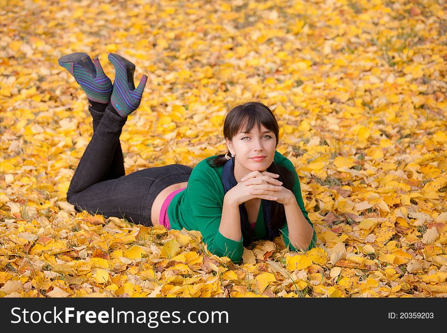 Girl  resting on yellow autumn leaves