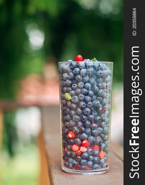 Colourful berries in the plastic glass on the balcony. Shallow dof. Colourful berries in the plastic glass on the balcony. Shallow dof