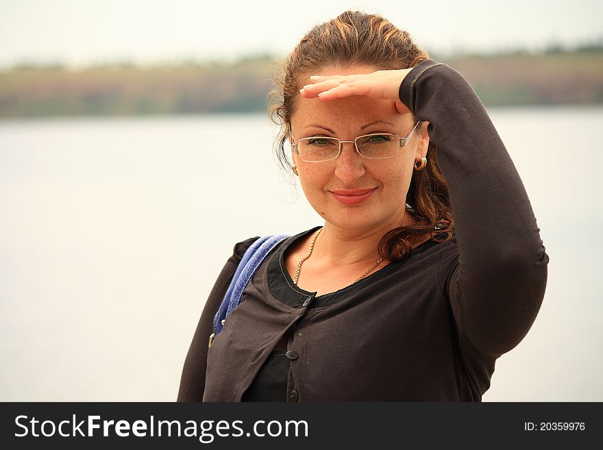 This photograph shows a beautiful young woman near a river. This photograph shows a beautiful young woman near a river.