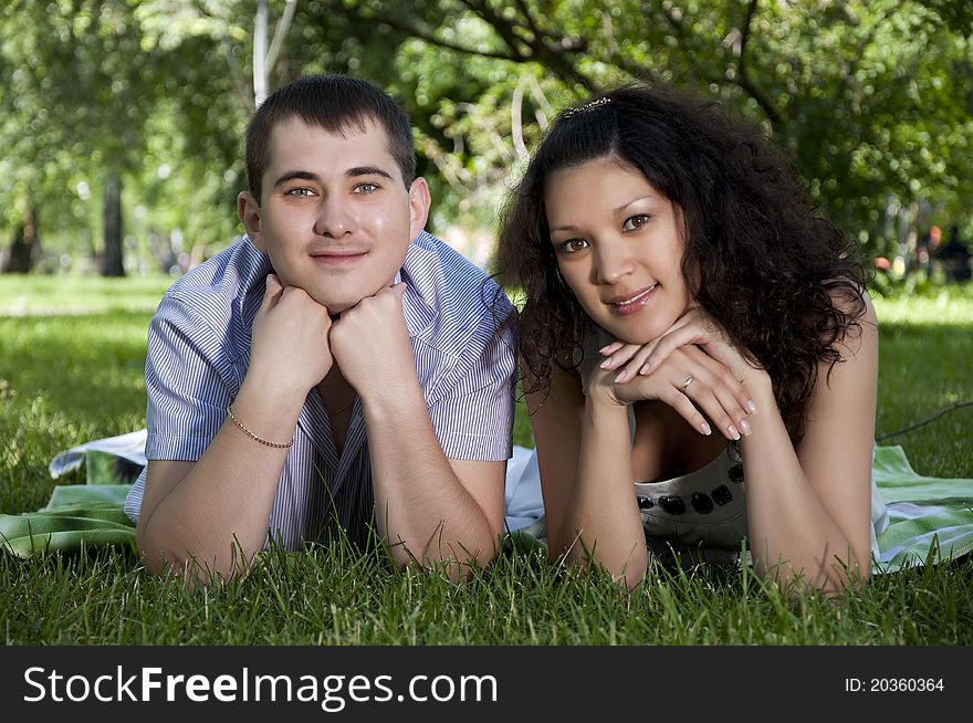 Couple lays together on a grass