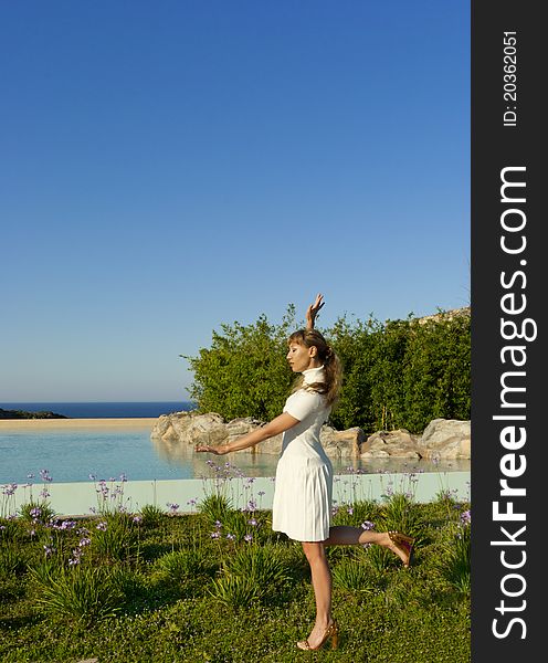 Beautiful woman meditating near water