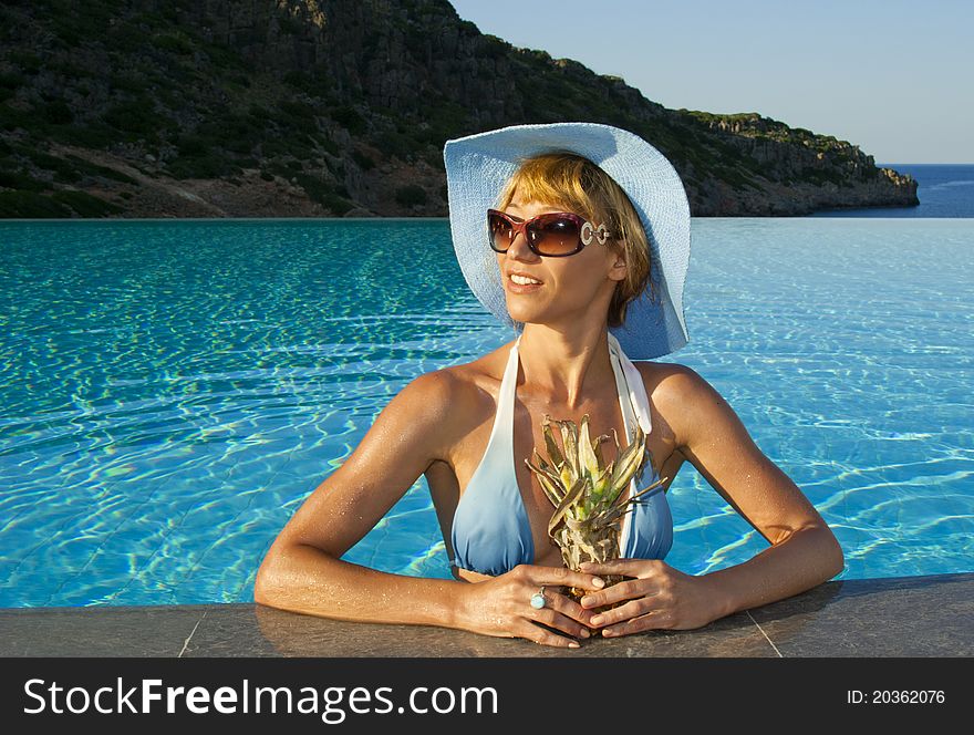 Beautiful woman in the swimming pool near coast