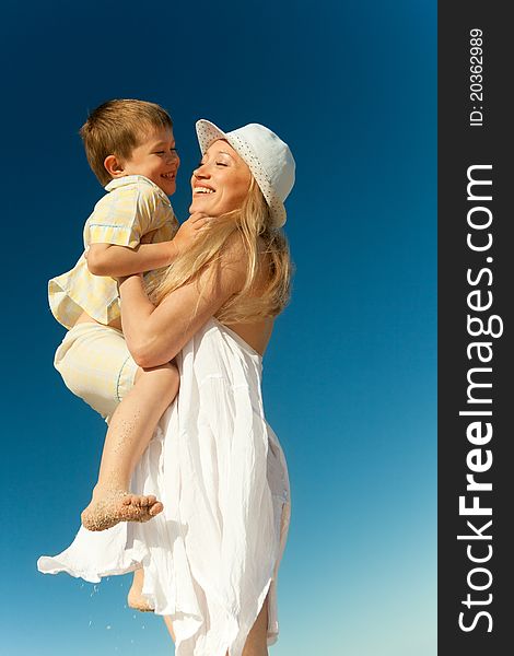 Boy flying on his mother's hands at beach