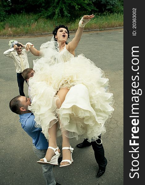 A happy bride tossed into sky by a group of groomsmen. A happy bride tossed into sky by a group of groomsmen
