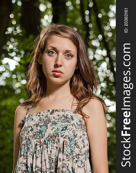 Portrait of attractive teen on green trees background