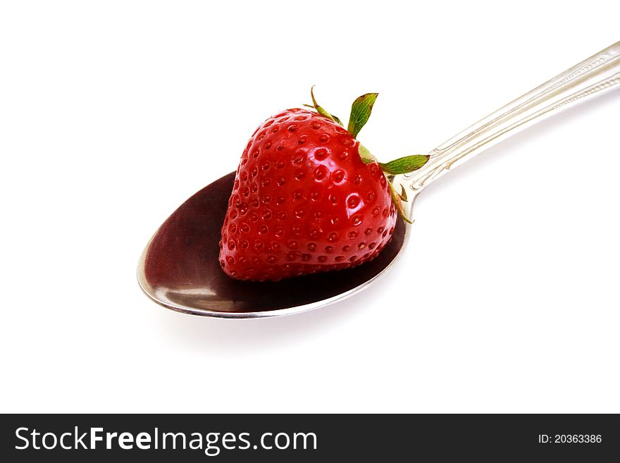 Zoomed foto of strawberry lying on metal spoon