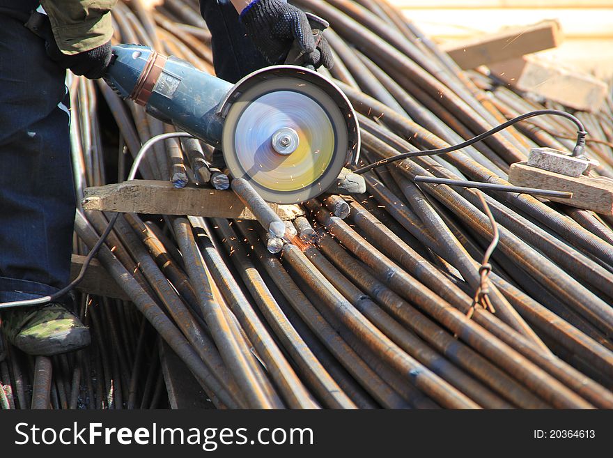 Construction worker cuts rebar circular saw