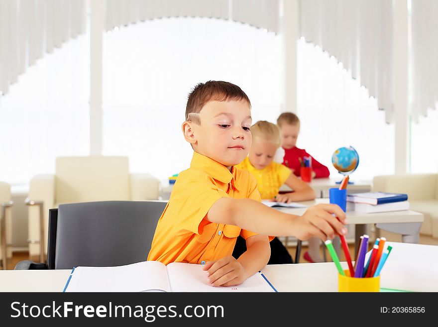 Portrait of a young boy sitting at his desk at school