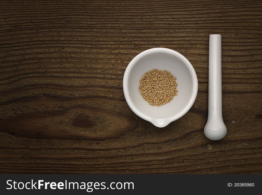 White ceramic mortar and pestle on wood background.