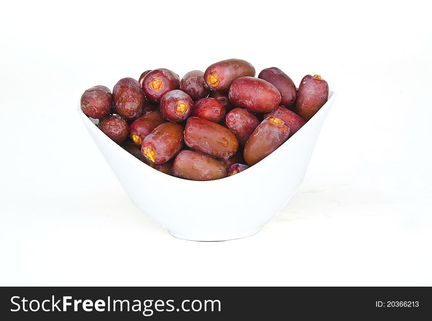 Plate full with Fresh red date fruits on white