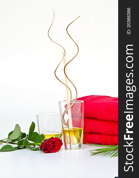 SPA Background of red towels and red rose with Massage Oil Glasses
