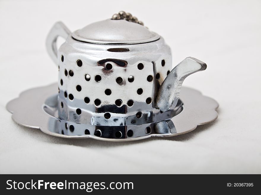 A silver teapot tea infuser