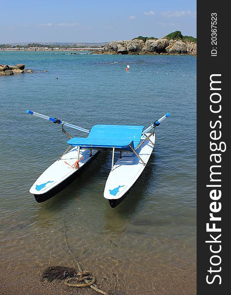 An italian twin-hulled rowboat with dolphin picture.