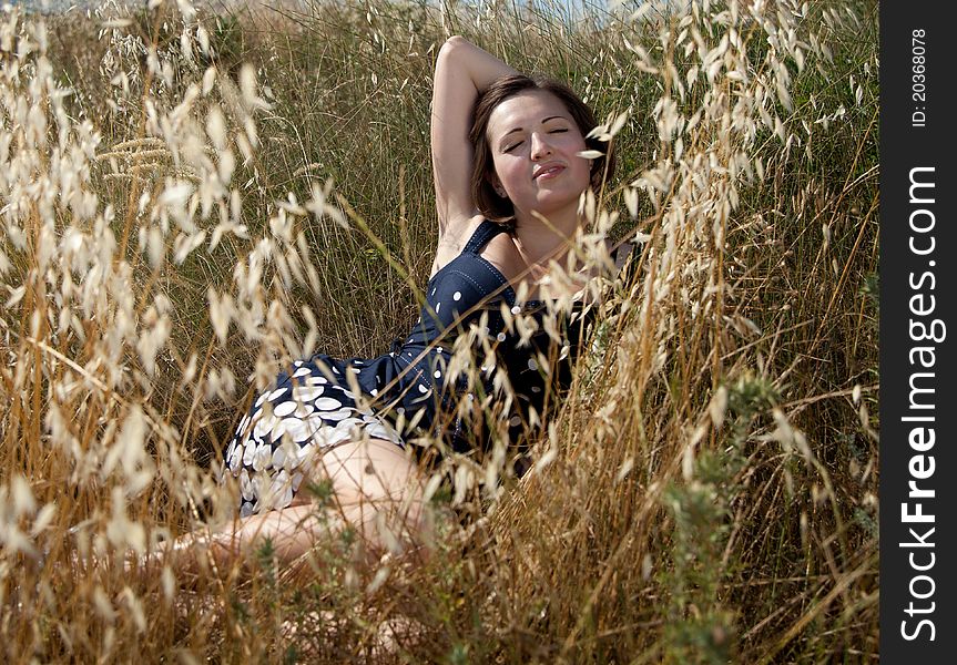 Outdoor shot of the young beautiful smiling woman laying on the grass. Outdoor shot of the young beautiful smiling woman laying on the grass