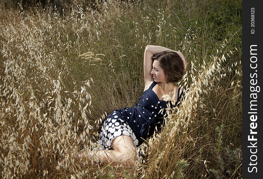 Outdoor shot of the young beautiful smiling woman laying on the grass. Outdoor shot of the young beautiful smiling woman laying on the grass