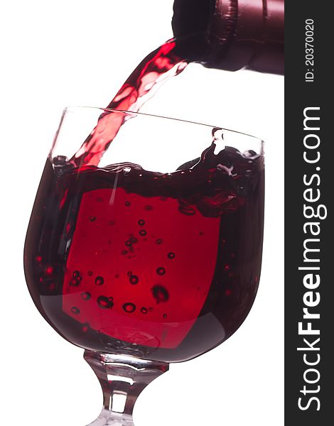 Red wine pouring down from a bottle into a glass over white background. Red wine pouring down from a bottle into a glass over white background