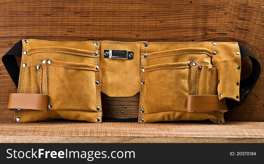 One empty suede  carpenter belt on wooden boards. One empty suede  carpenter belt on wooden boards