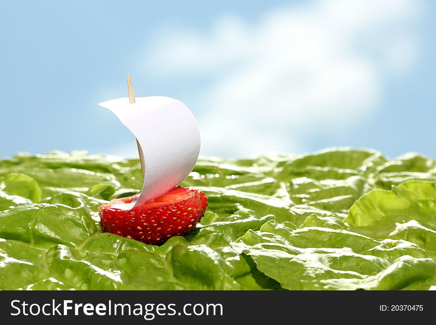 Boat, made of fresh strawberry on lettuce leaves