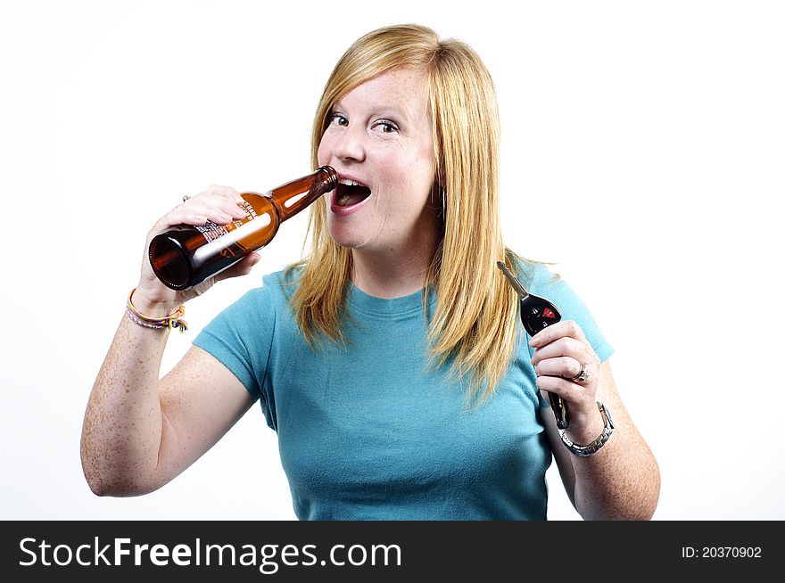 A woman drinking a beer while she holds a car key and beer bottle in her hands. A woman drinking a beer while she holds a car key and beer bottle in her hands.