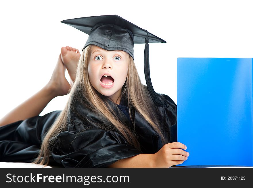 Portrait of cute girl in black academic cap with liripipe and gown reading big blue book on isolated white. Portrait of cute girl in black academic cap with liripipe and gown reading big blue book on isolated white
