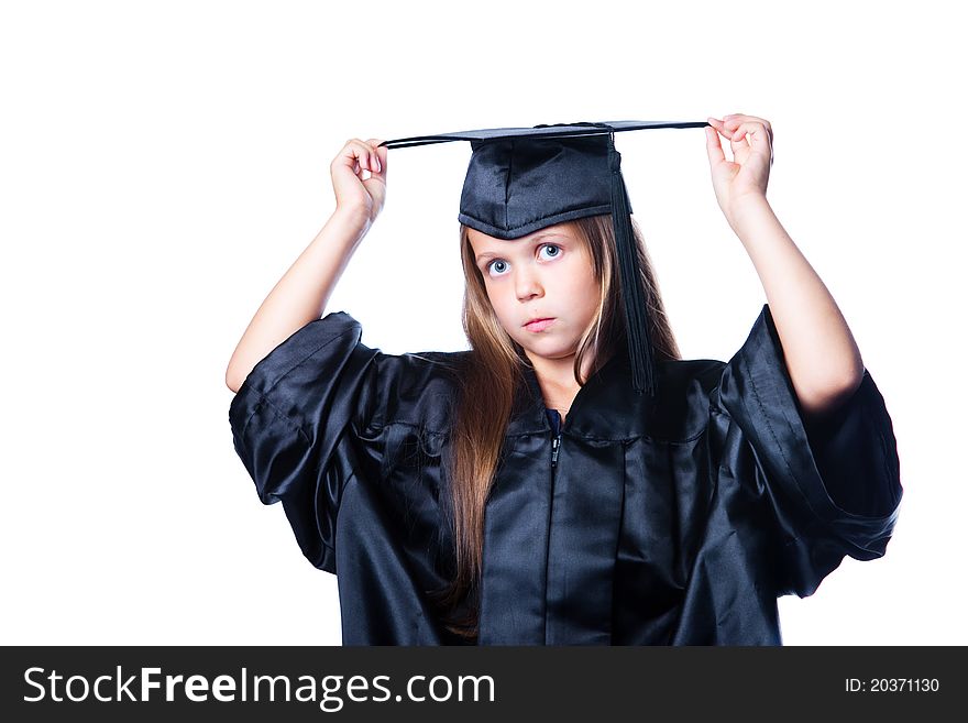 Portrait of cute serious girl in black academic cap with liripipe and gown on isolated white. Portrait of cute serious girl in black academic cap with liripipe and gown on isolated white