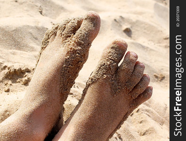 Girl`s barefoot legs in the sand. Girl`s barefoot legs in the sand