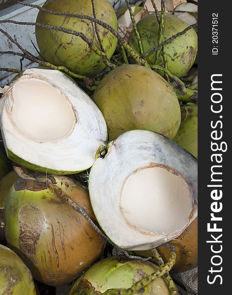 Green coconuts in bunch and split open