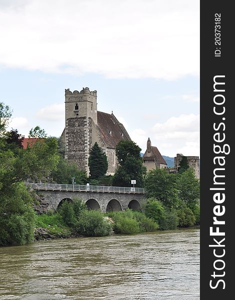 Medieval castle next to a running river access by bridge. Medieval castle next to a running river access by bridge