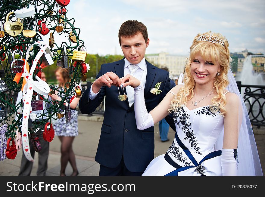 Happy bride and groom at wedding walk on Luzhkov bridge in Moscow. Happy bride and groom at wedding walk on Luzhkov bridge in Moscow