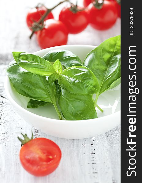Fresh basil and tomatoes in bowl