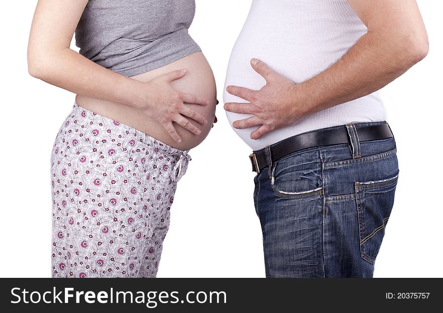 Studio-shot of a pregnant woman of Identical (monozygotic) twins and her husband. young couple standing togehter and showing bellies. concept image for pregnancy, isolated on white. Studio-shot of a pregnant woman of Identical (monozygotic) twins and her husband. young couple standing togehter and showing bellies. concept image for pregnancy, isolated on white.