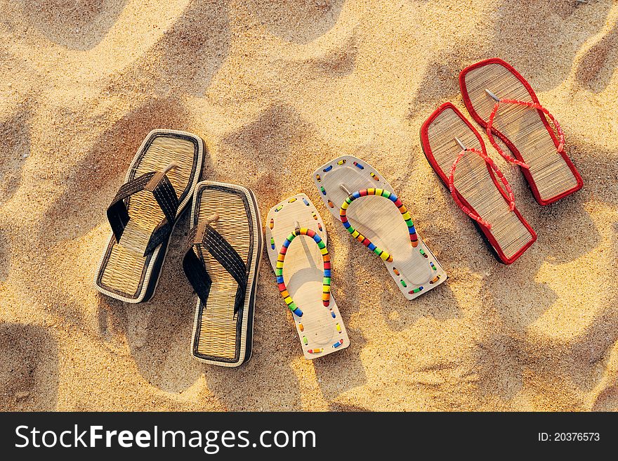 Three pair of beach sandals on the sandy beach. Three pair of beach sandals on the sandy beach